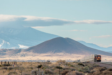 Small train and distant mountains give scale