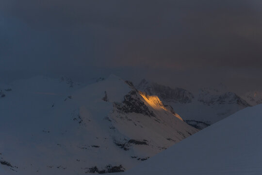 Sun sets on a mountain range in the Northern Rockies in Canada.