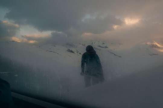 A man shovels snow outside a hut in the Northern Rockies in Canada.