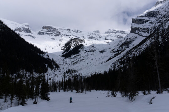 A skier descends a valley in the Canadian backcountry.