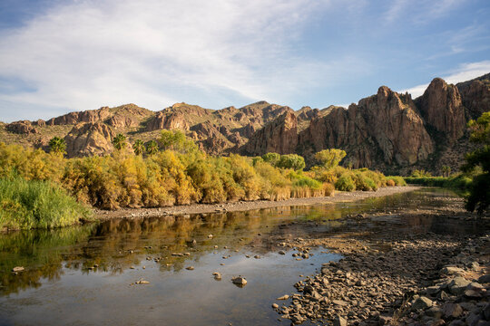 Mountainous rugged desert landscape and waterway in afternoon light