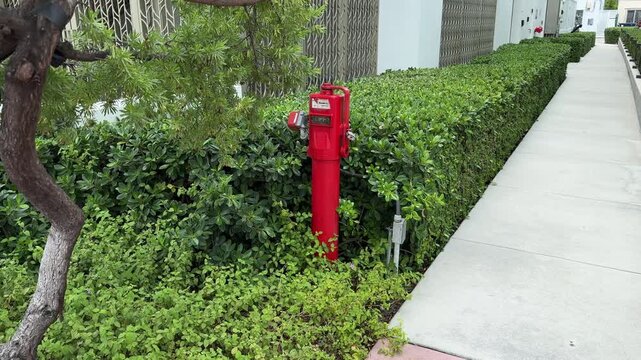 Miami Beach, Florida, USA, June 27, 2025: A red Indicator Post manufactured by Mueller Co. in Miami Beach. The Indicator Post provides a means to operate a buried or otherwise inaccessible valve.
