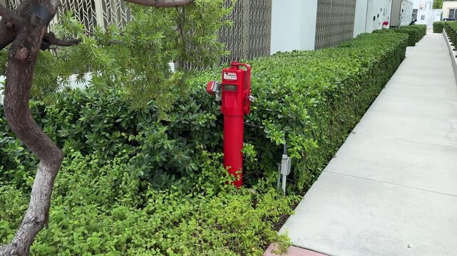 Miami Beach, Florida, USA, June 27, 2025: SM - A red Indicator Post manufactured by Mueller Co. in Miami Beach. The Indicator Post provides a means to operate a buried or otherwise inaccessible valve.