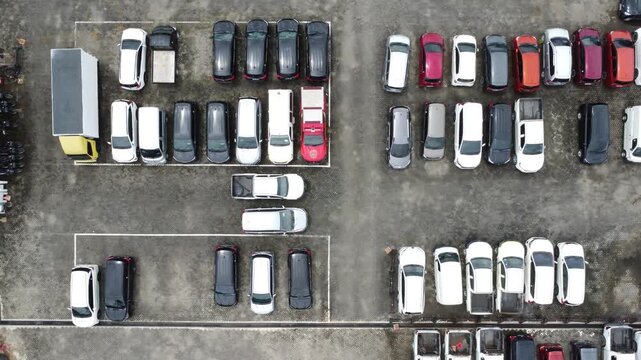 Aerial view of a parking lot lined up with cars for rent