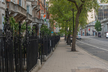Cozy Neighborhood Corridor Bordered By Tall Trees And Decorative Gates, London - May 2025