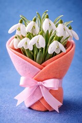Elegant snowdrop bouquet wrapped in pastel felt, tied with a delicate ribbon.