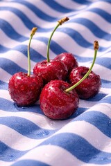 Fresh cherries on a striped cloth, glistening with droplets of water. Summer treat.