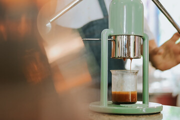 Barista's hands extracting fresh espresso using a manual lever machine.