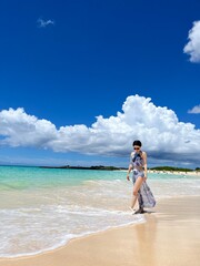 Woman Walking Along a Tropical Beach with Blue Sky and Copy Space