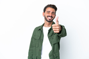 Naklejka premium Young caucasian man isolated on white background with thumbs up because something good has happened