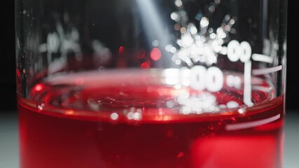 Abstract extreme close-up of brilliant light refracting through ruby red synthetic oil inside a perfectly clean scientific glass beaker showcasing vibrant color science, conceptual, engineering