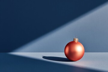 Shiny red ornament casts delicate shadows on blue background, hi