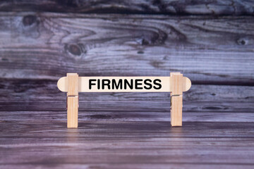 Fototapeta premium Firmness symbol. A wooden stick secured by Clothespins set over beautiful Realistic Wooden Texture Background. Business and Firmness concept with copy space