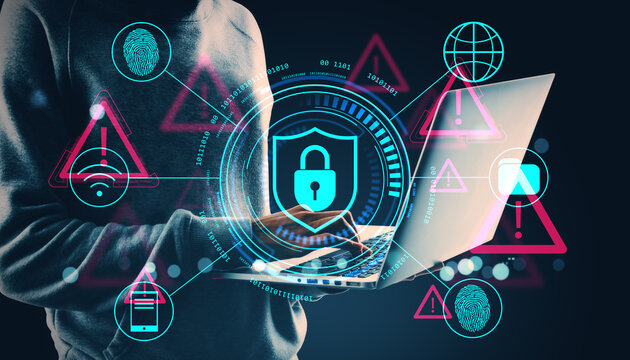 Cybersecurity concept showing digital padlock shield icon with holographic symbols around person using laptop in dark tech-themed background.