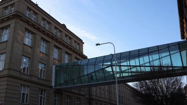 Modern glass skybridge connecting office buildings above city street creating futuristic corporate architecture scene with urban mobility business travel and daily commuting