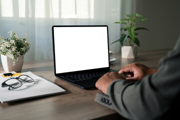 Remote work concept with modern laptop, coffee mug and office supplies arranged neatly on wooden home office desk near window, creating a clean productive workspace for freelancers and small business.