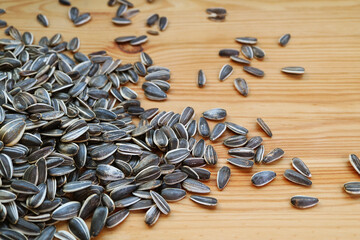 Raw sunflower seeds scattered on wooden table