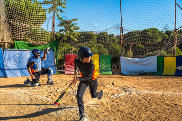 Kids playing baseball, batter running to first base