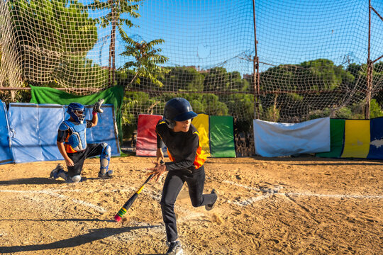 Kids playing baseball, batter running to first base