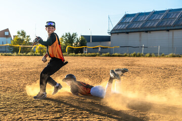 Baseball player sliding into base during game