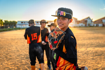 Young baseball player smiling holding glove on field
