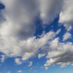 Obraz premium Blue sky background with scattered white cumulus clouds