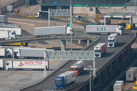 HIGH ANGLE VIEW, CLOSE UP: Trucks moving along winding roads at seaport terminal