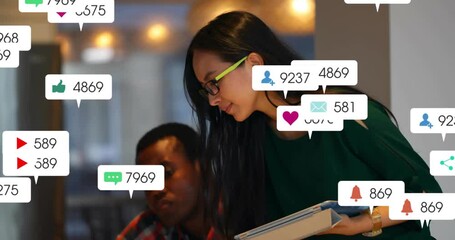 Female colleague tapping tablet spawning social media alerts showing engagement data - Powered by Adobe