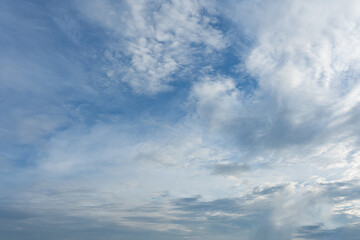 Obraz premium Blue sky with mixed white and gray clouds displaying various atmospheric textures and formations