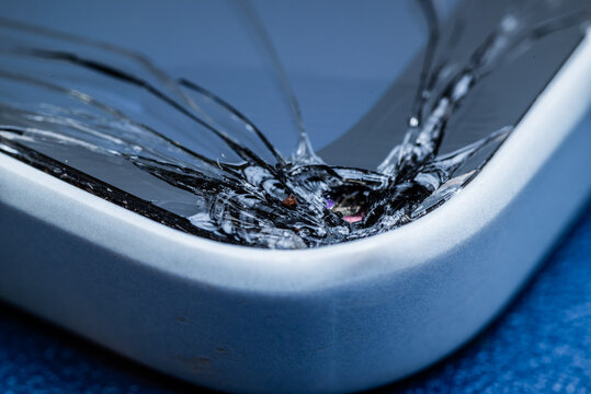Close-up of a cracked smartphone screen corner showing broken glass damage on a modern mobile device. Concept of technology failure, repair service, accidental damage, and device protection.