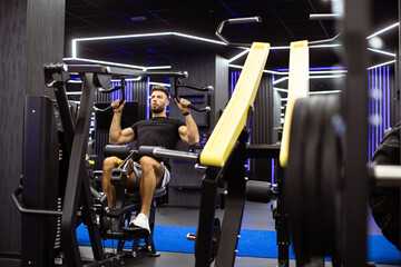 Focused fitness enthusiast working out on modern exercise equipment in a stylish gym