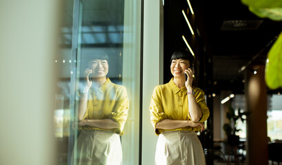 Happy woman talking on the phone in a modern office setting