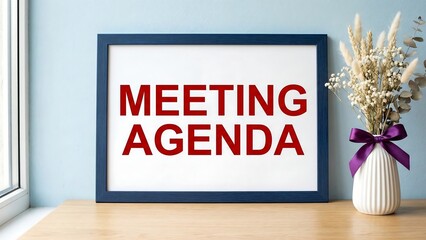 Meeting agenda symbol. Concept words Meeting agenda on beautiful wooden picture frame. Beautiful light blue background with flower vase. Business and Meeting agenda concept. 