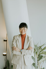 Business professional stands confidently in modern office space with plants