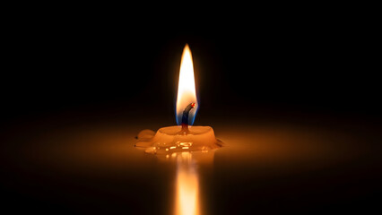 A solitary burning candle illuminating the darkness with a warm glow and melted wax