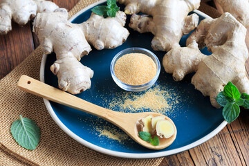  Ingwerpulver mit ingwerknollen auf einem Teller