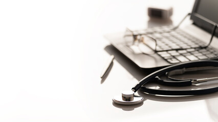 Healthcare background of stethoscope pulse oximeter laptop glasses and pen on table with copy-space