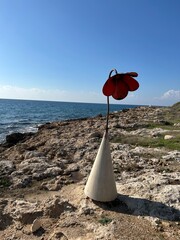 ozdobny betonowo metalowy kwiat na brzegu morza © Piotr