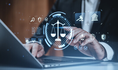 Digital law and justice concept with businessperson using laptop and virtual legal icons over blurred background in modern creative composition.