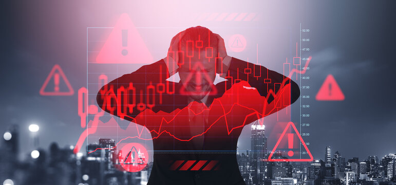 Stressed trader holding head with crashing red stock market char