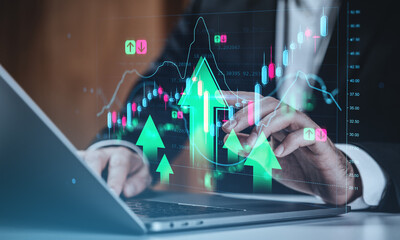 Businessman analyzing forex and stock market charts with digital arrows indicating growth on futuristic trading interface background in office setting.
