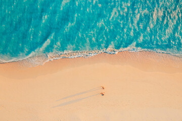 Romantic couple walking along tropical Mediterranean beach at sunset with calm ocean waves soft sand idyllic summer vacation travel destination serene nature scenic paradise seaside background