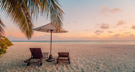 Majestic sunset beach scene, romantic couple chairs under umbrella palm trees calm ocean view warm golden light tropical summer honeymoon vacation luxury resort travel background serene seaside