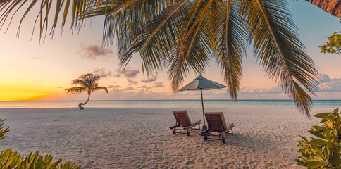 Majestic sunset beach scene, romantic couple chairs under umbrella palm trees calm ocean view warm golden light tropical summer honeymoon vacation luxury resort travel background serene seaside