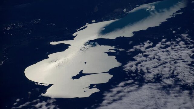 Lake Balkhash freshwater reservoir at dawn, aerial flying over with clouds from space, based on NASA imagery