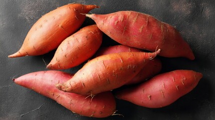 Vibrant sweet potatoes on dark rustic background.
