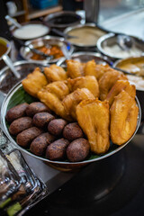 Traditional Indonesian street food featuring pisang goreng fried banana and timus ubi ungu purple sweet potato fritters served on banana leaf. Authentic local snack and cultural cuisine concept © MithaArini