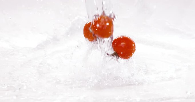 Fresh water splash on red Cherry tomatos. Shot on super slow motion camera 1000 fps.