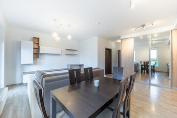Fototapeta premium Modern Home Living and Dining Room with Minimalist Decor and Wooden Accents. Dining Table