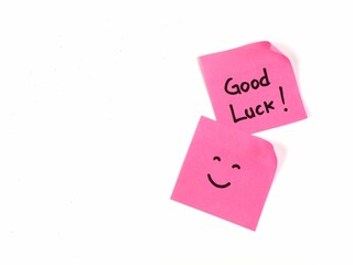 Pink sticky notes with good luck text and smiley face on white background. positive vibes, motivation, and support concept 